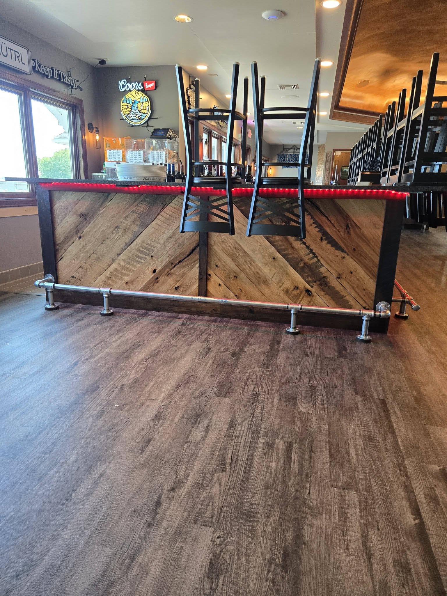 Restaurant bar with reclaimed wood facing and pipe rail